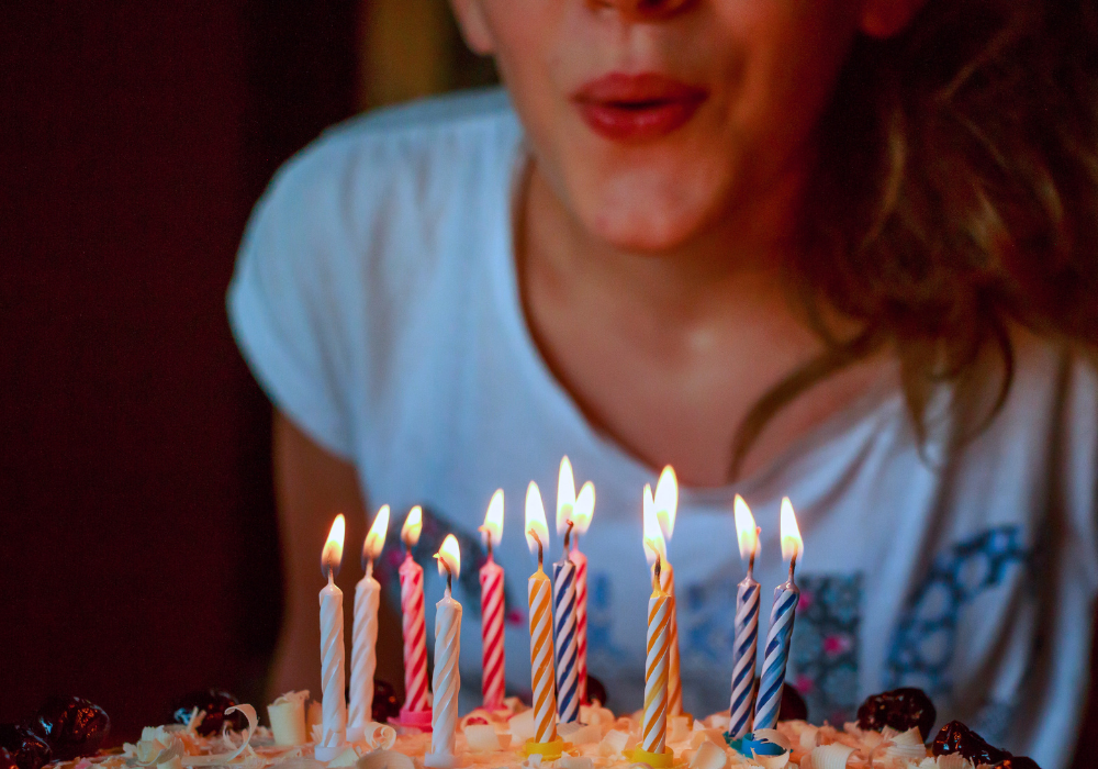 A close up of a young girl blowing out candles on a cake for her birthday/